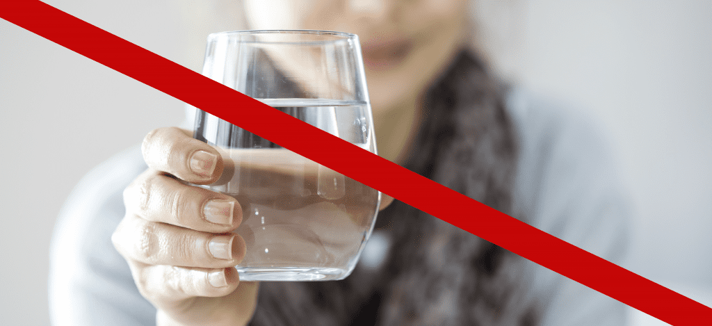 Frau mit nicht trinkbarem Wasser im Glas