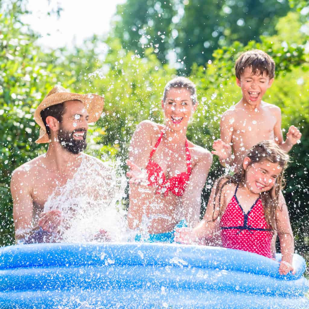Eine Familie planscht mit Wasser im Pool