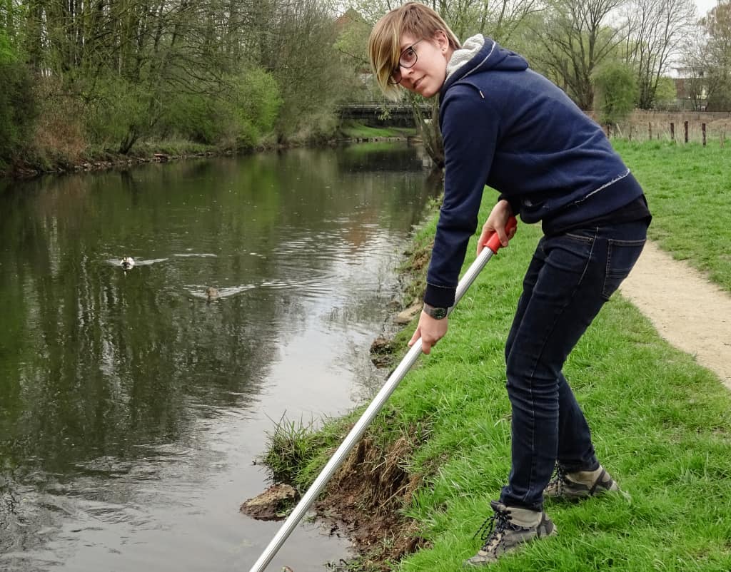 Bundesfreiwilliger des VSR-Gewaesserschutz entnimmt einem Fluss eine Wasserprobe