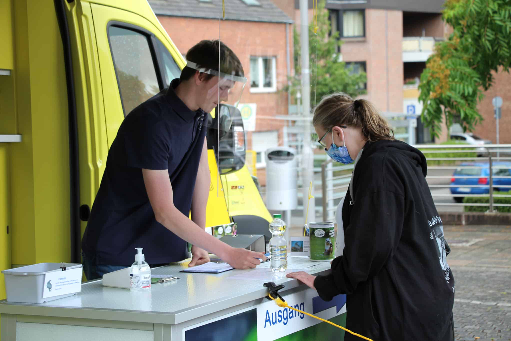Ein Teammitglied vom VSR-Gewässerschutz berät eine Brunnenbesitzerin an einem Informationsstand in einer deutschen Stadt vor dem Labormobil