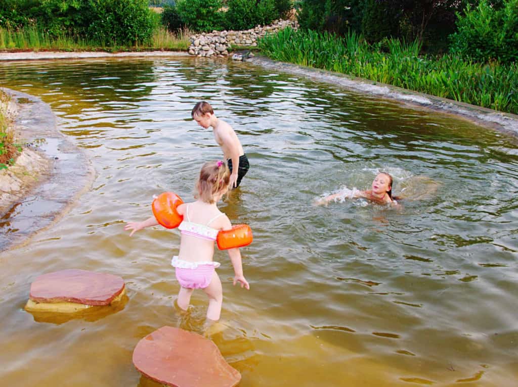 Spielende Kinder in einem Teich