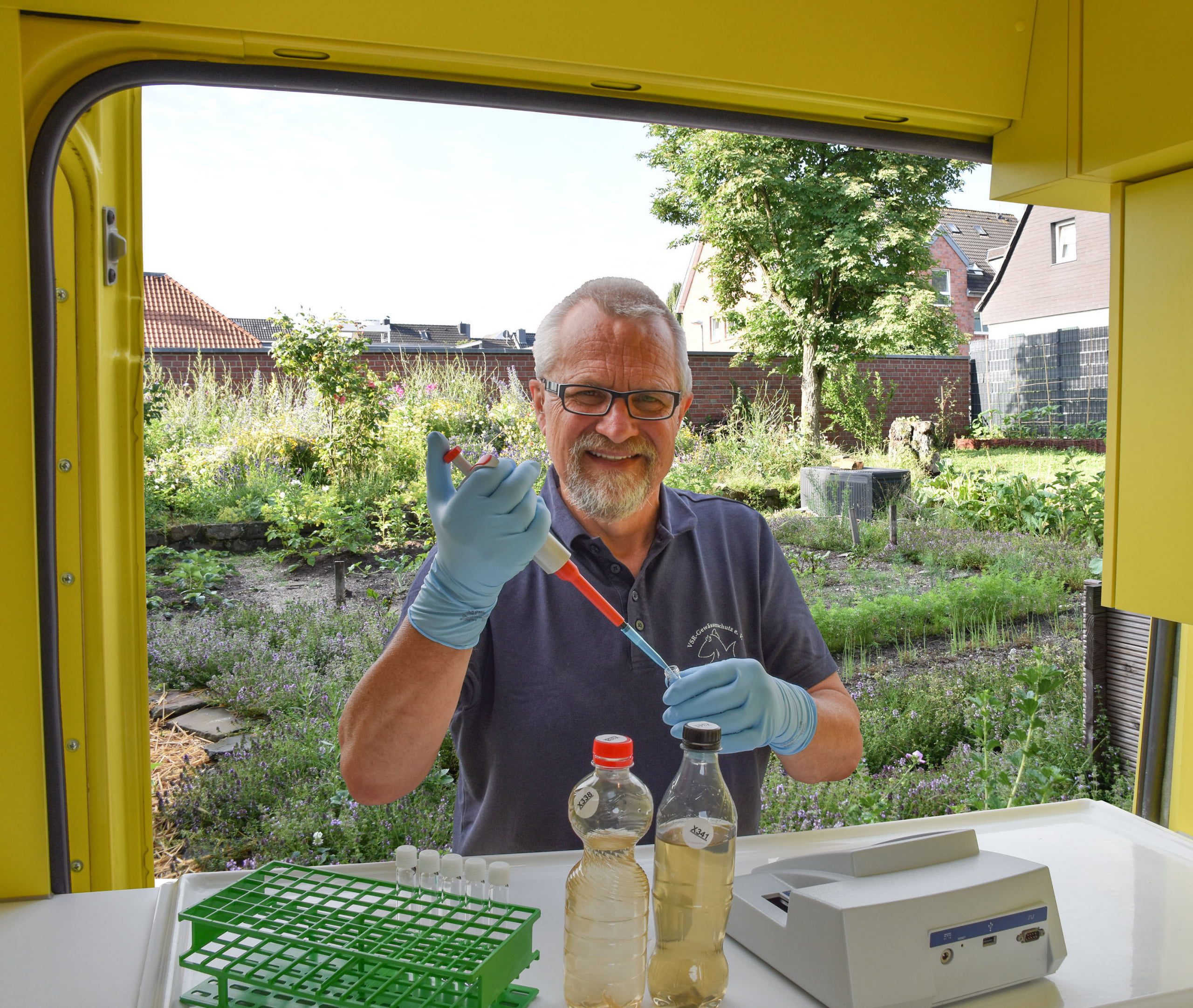 Harald Gülzow analysiert eine Brunnenwasserprobe im Labormobil