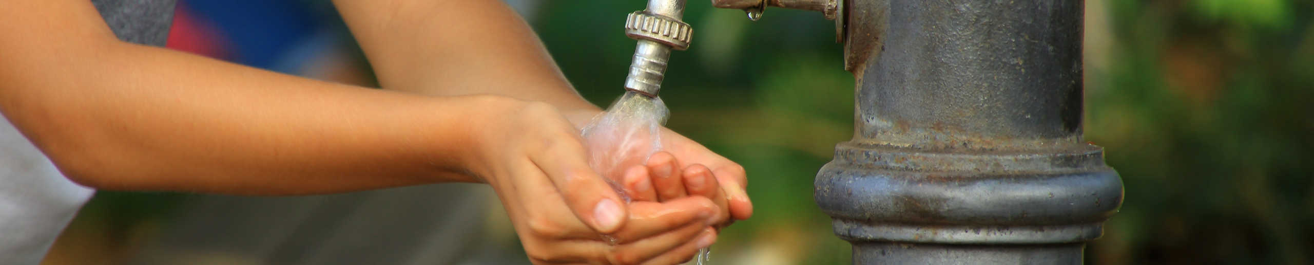 Kind sammelt mit seinen Händen Wasser