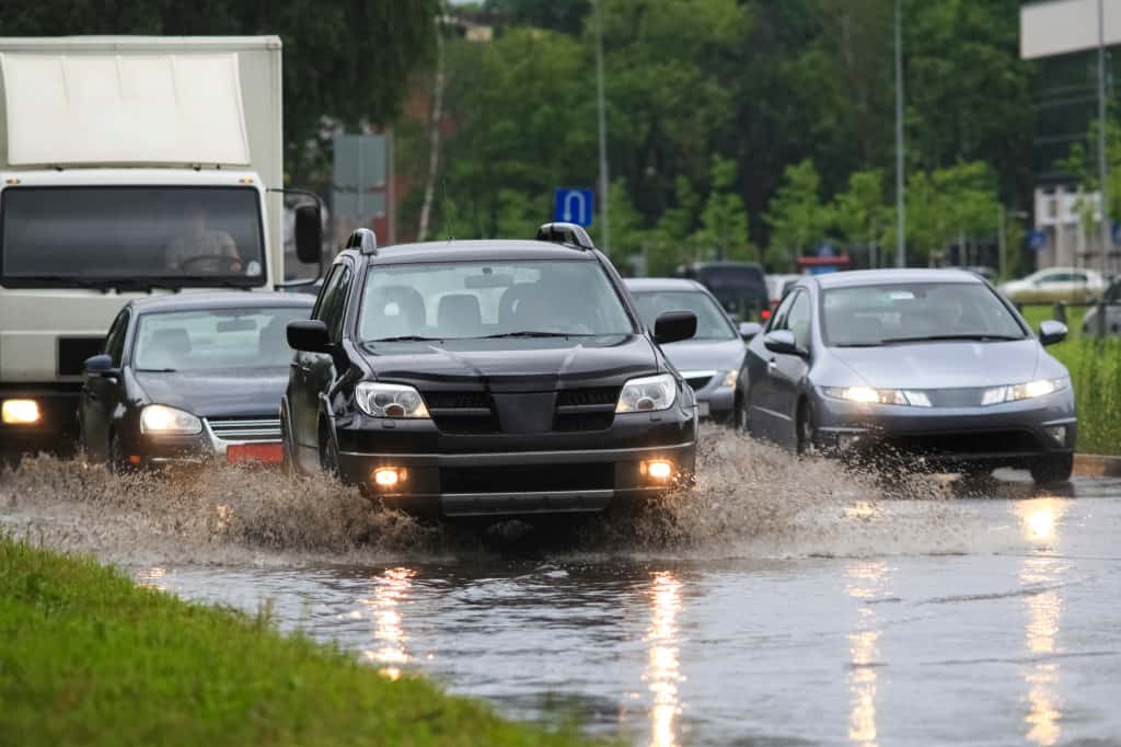 Autos fahren durch Hochwasser in der Stadt