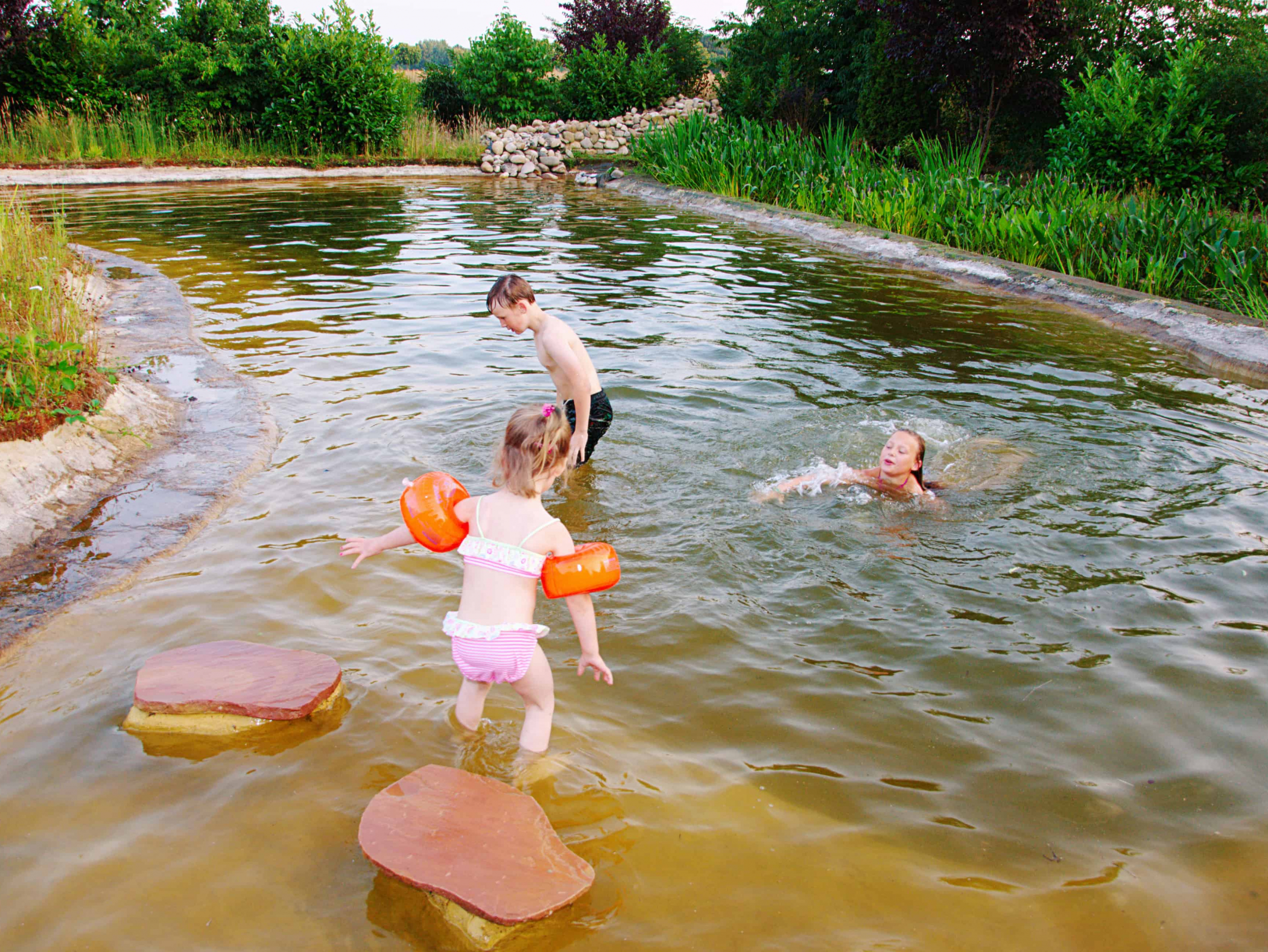Kinder spielen in Teich