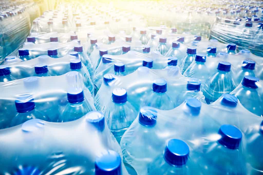 viele Sechser-Packs Wasser sind in Plastik eingepackt