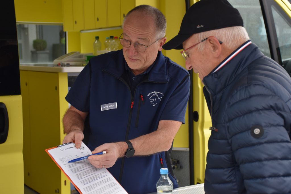 Der ehrenamtliche Mitarbeiter Geog Stüker (links) vom VSR-Gewässerschutz berät am Labormobil einen Brunnennutzer