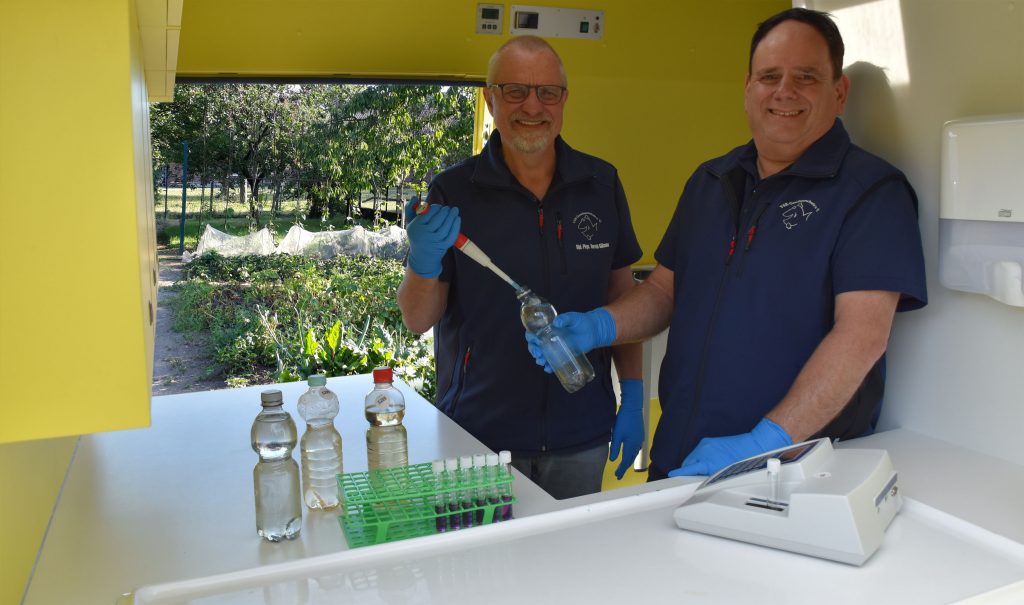 Harald Gülzow (links) und Frank Sombrowski (rechts) untersuchen eine Brunnenwasserprobe im Labormobil vom VSR-Gewässerschutz