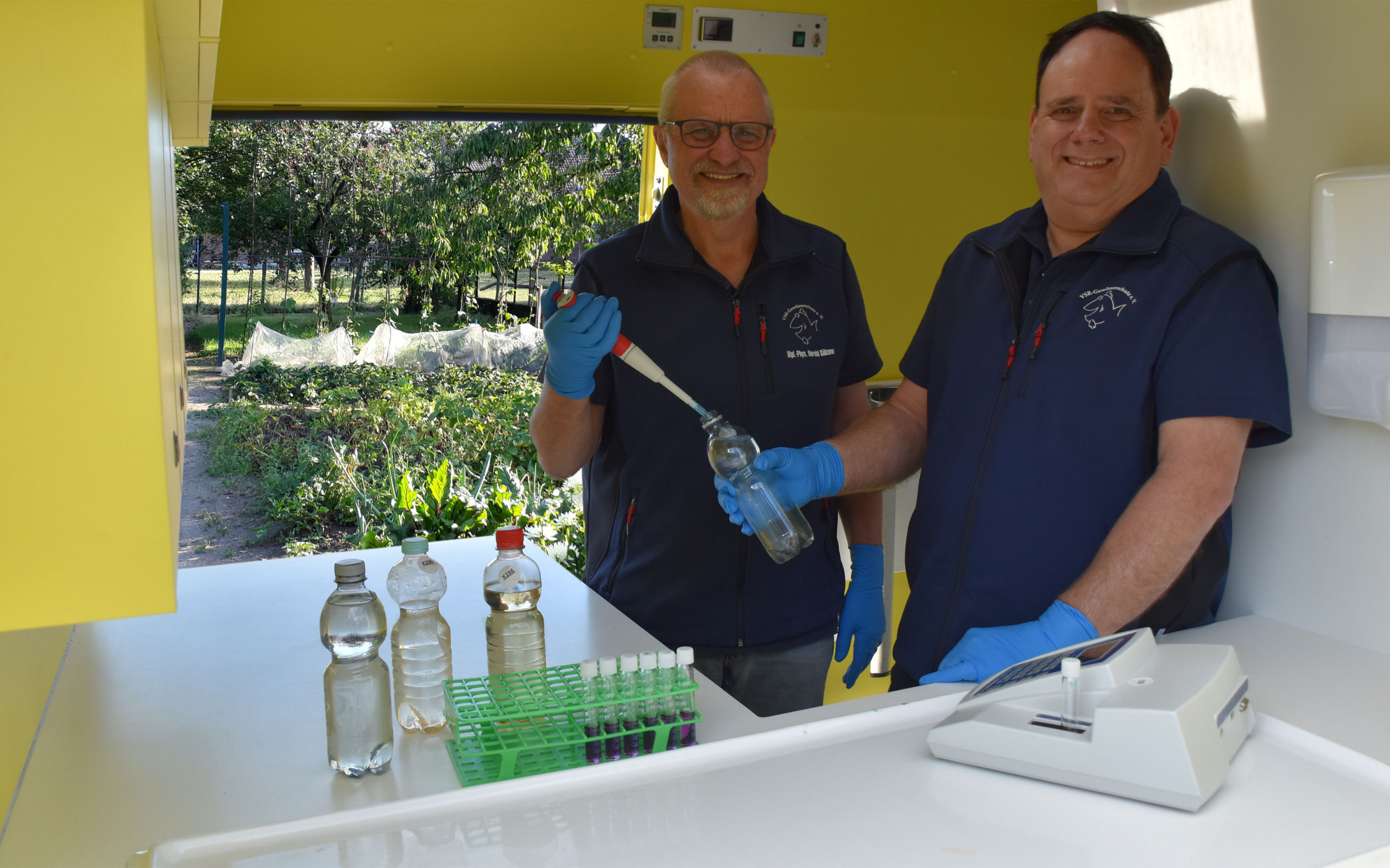 Harald Gülzow (links) und Frank Sombrowski (rechts) untersuchen eine Brunnenwasserprobe im Labormobil vom VSR-Gewässerschutz