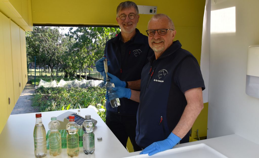 Heinz-Theo van Wickeren (links) und Harald Gülzow (rechts) untersuchen eine Brunnenwasserprobe im Labormobil vom VSR-Gewässerschutz