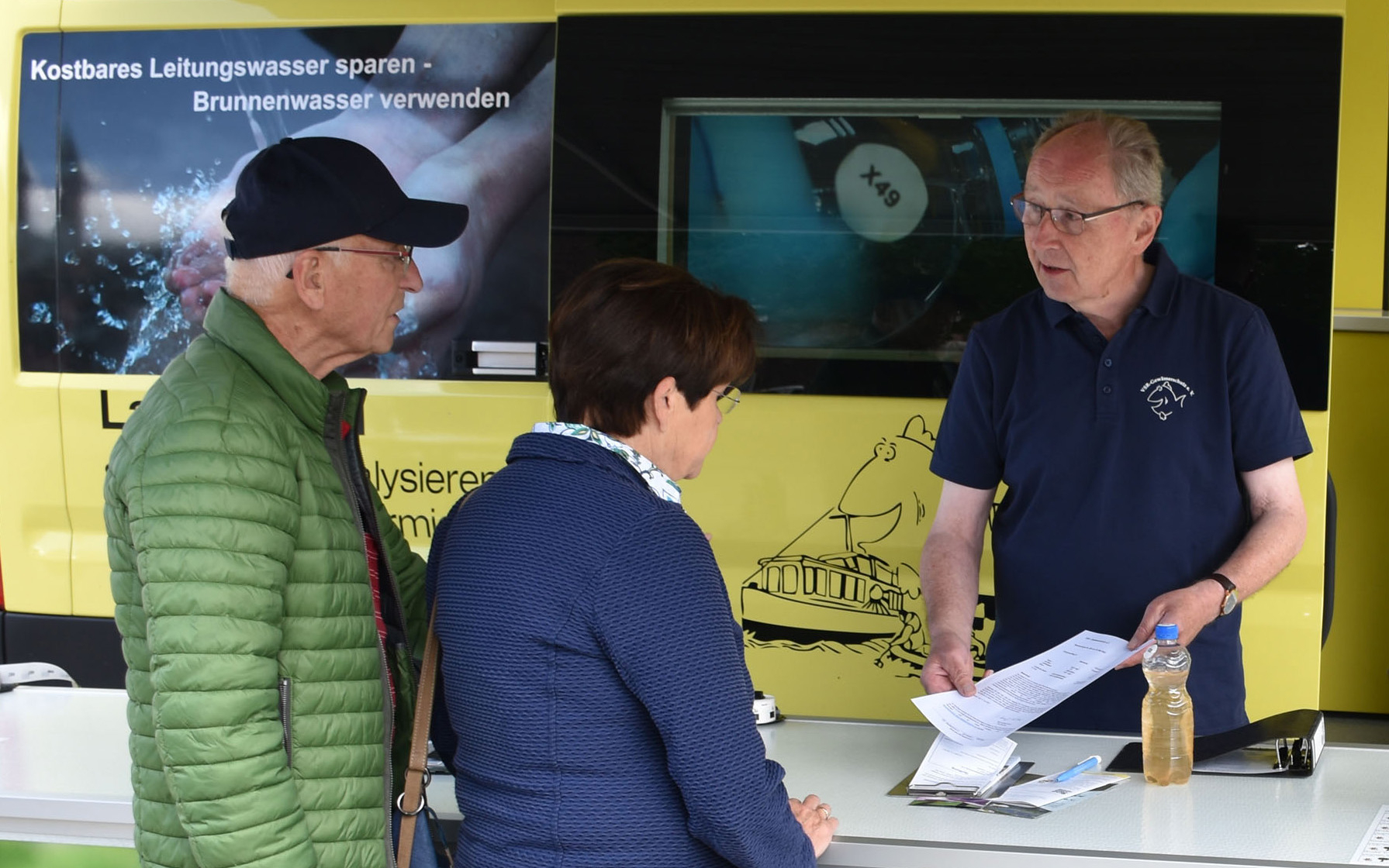 Heinz-Wilhelm Hülsmans (dritte Person von links), ehrenamtlicher Mitarbeiter beim VSR-Gewässerschutz, berät Brunnenbesitzer am Informationsstand des Labormobils.