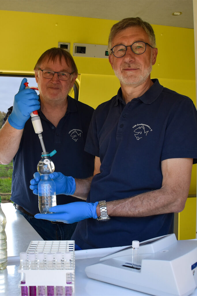 Arno Mittelmeyer und Heinz-Theo van Wickeren untersuchen eine Brunnenwasserprobe im Labormobil des VSR-Gewässerschutz e.V Fotograf Ruben Wiltsch
