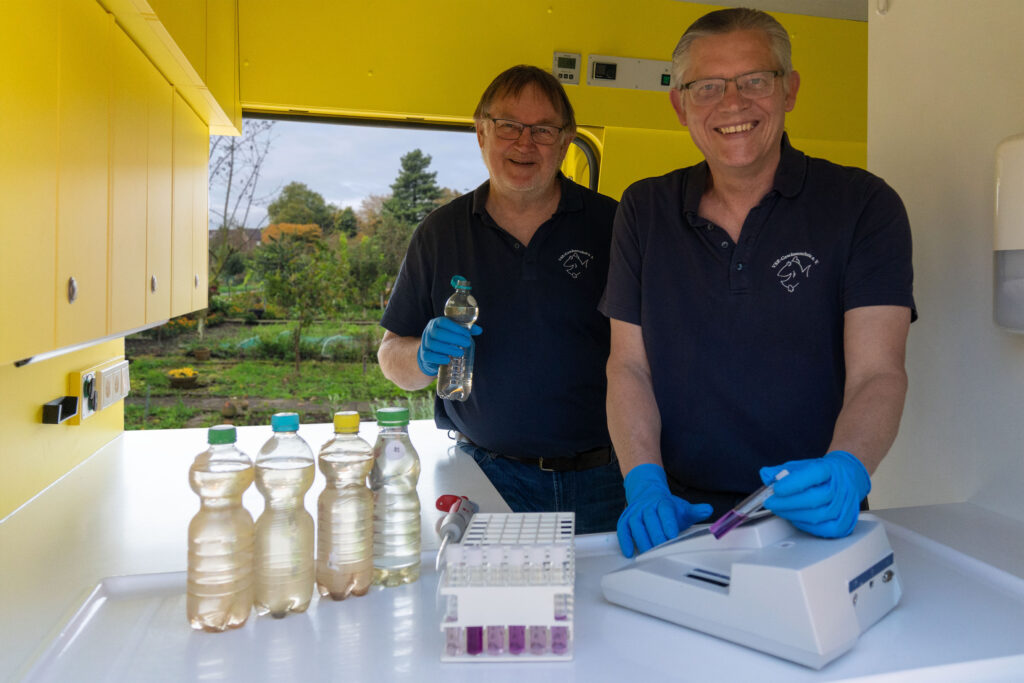Arno Mittelmeyer und Matthias Ahlbrecht untersuchen eine Brunnenwasserprobe im Labormobil des VSR-Gewässerschutz e.V Fotograf Ruben Wiltsch