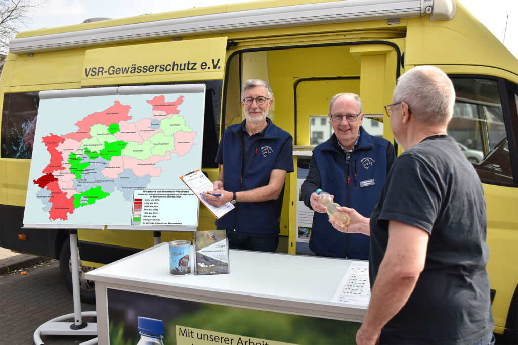 Heinz-Theo van Wickeren (links) und Heinz-Wilhelm Hülsmans (rechts) beraten einen Brunnenbesitzer am Labormobil des VSR-Gewässerschutz