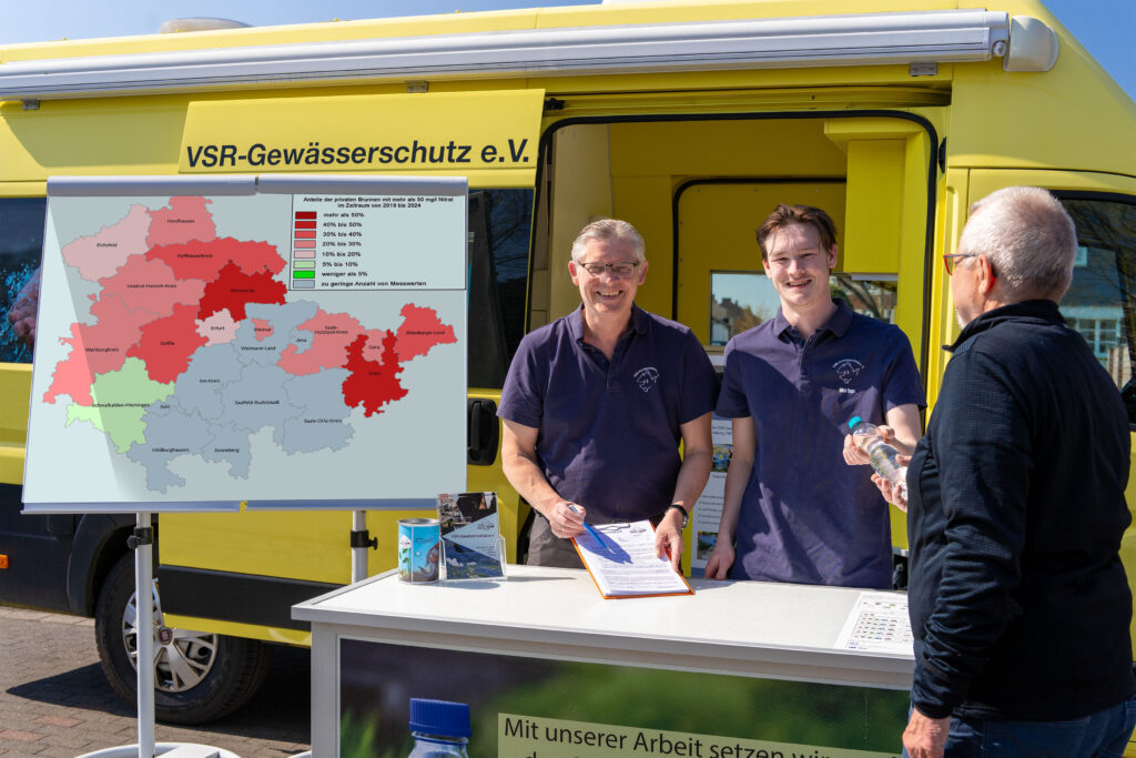 Matthias Ahlbrecht und Milan Toups beraten einen Brunnenbesitzer mit Nitratkarte Thüringen vor einem Labormobil des VSR-Gewässerschutz e.V. Fotograf Ruben Wiltsch