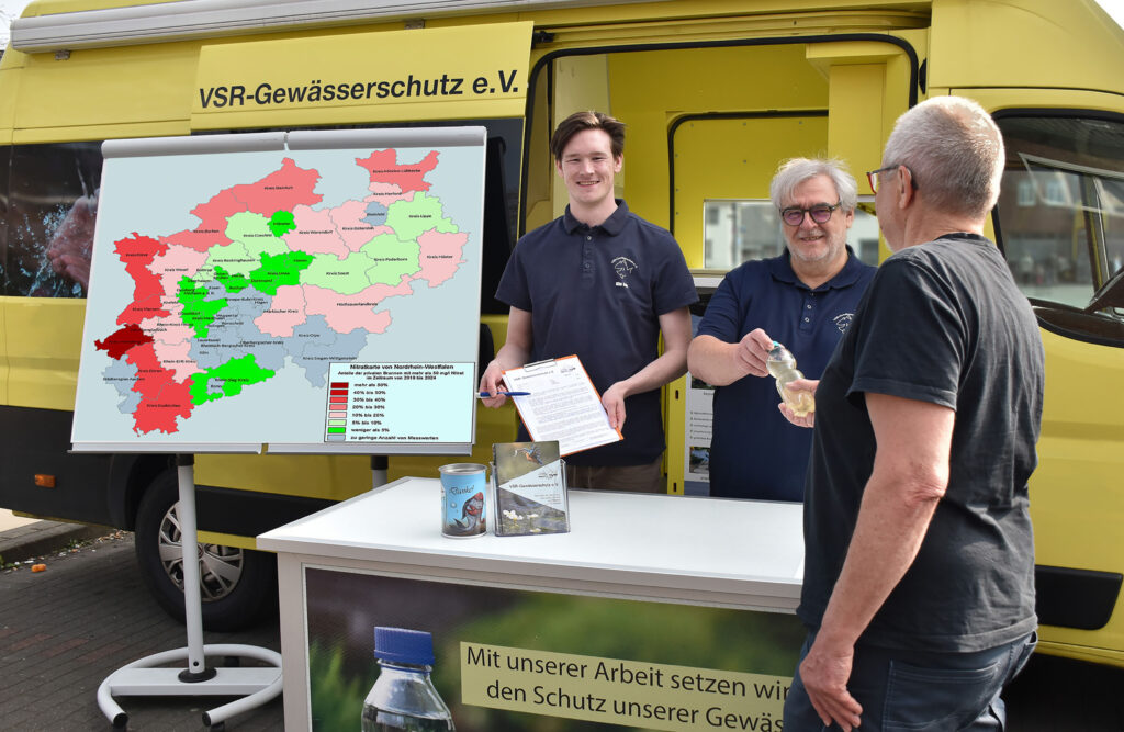 Milan Toups (links) und Helmut Hartmann (rechts) beraten einen Brunnenbesitzer mit Nitratkarte NRW am Labormobil des VSR-Gewässerschutz Fotograf Ruben Wiltsch
