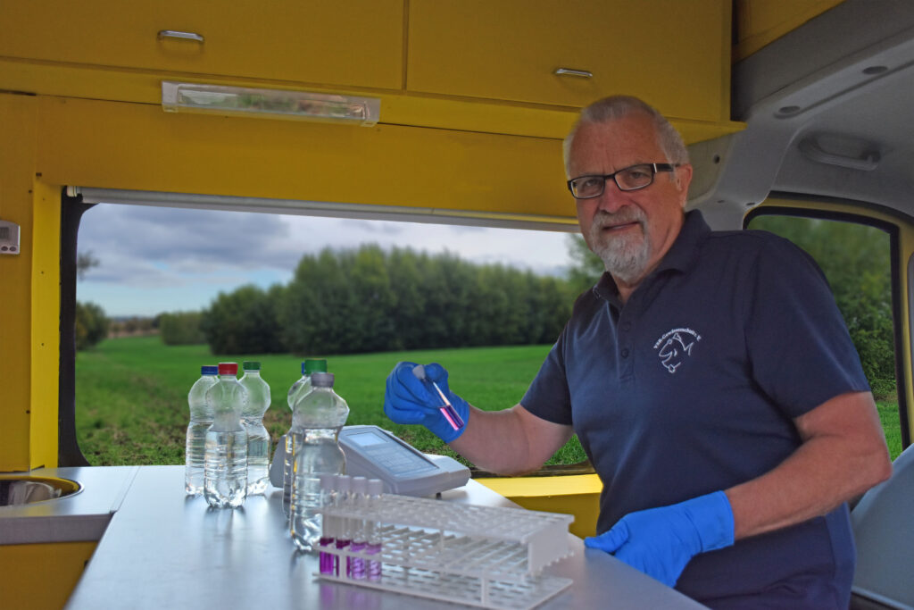 Harald Gülzow untersucht eine Probe an einem Agroforstsystem