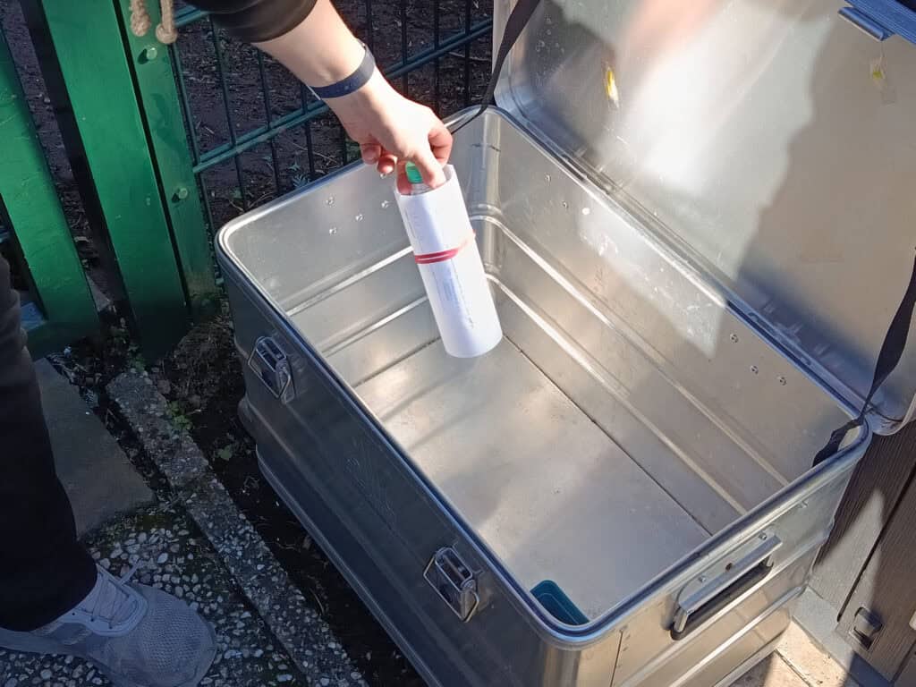 Abgabe einer Wasserflasche an der Ablagekiste