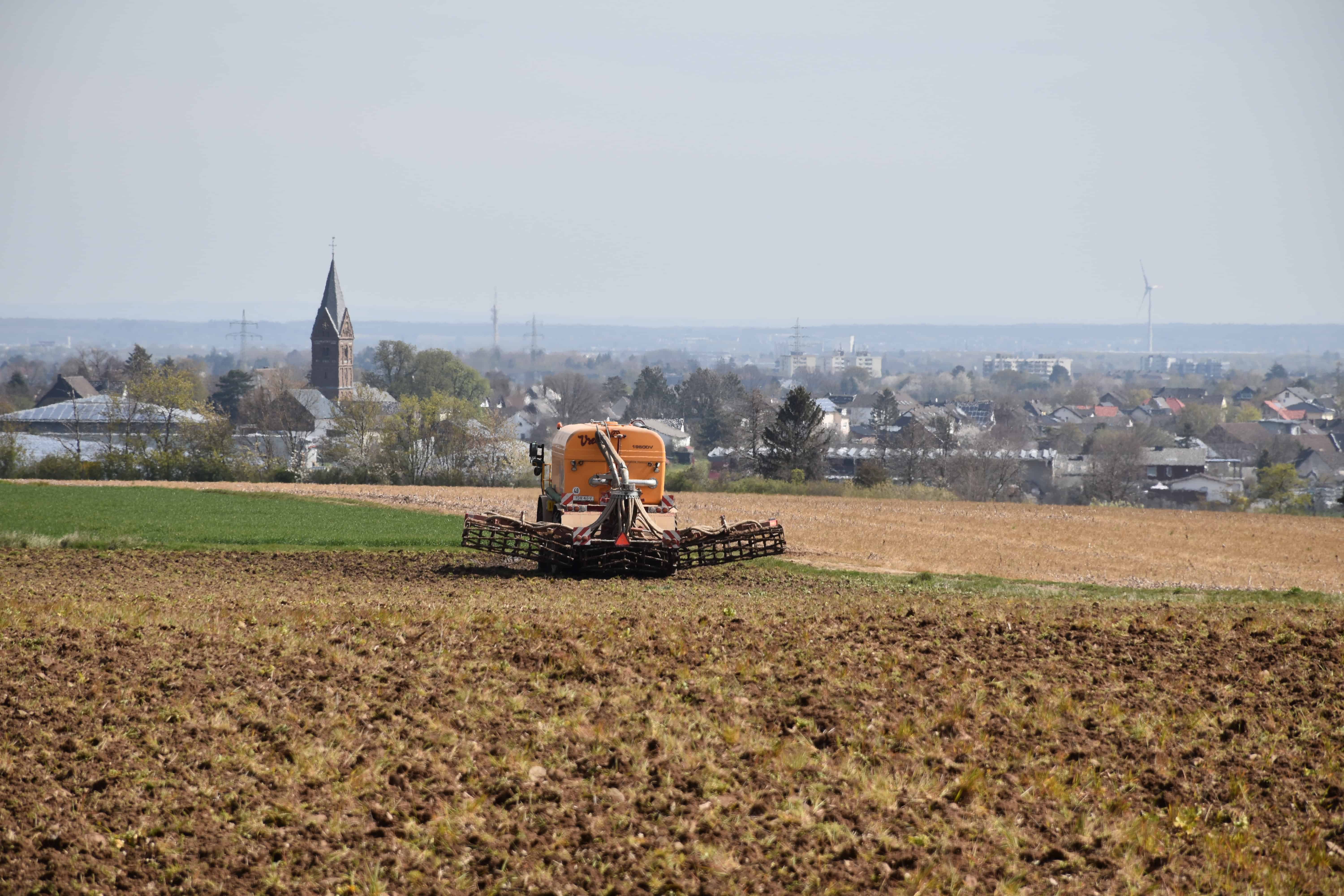 Ein Trecker mit Gülleanhänger auf einem Feld