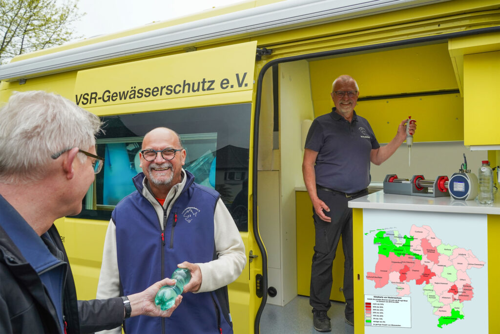 Frank Hage und Harald Gülzow beraten einen Brunnenbesitzer und untersuchen eine Brunnenwasserprobe, Fotograf Ruben Wiltsch